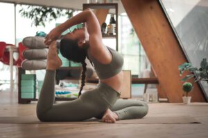 Woman practicing yoga in a modern home studio. She is performing a seated spinal twist.