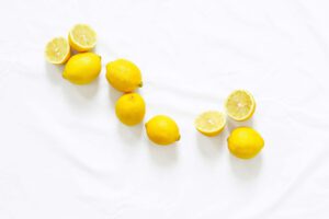 Fresh lemons arranged on white fabric.