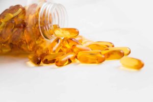 Amber fish oil capsules spilling from a bottle