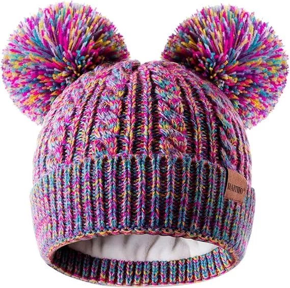 Colorful double pom pom kids' beanie for a warm winter. Features cable knit design and a fleece lining.